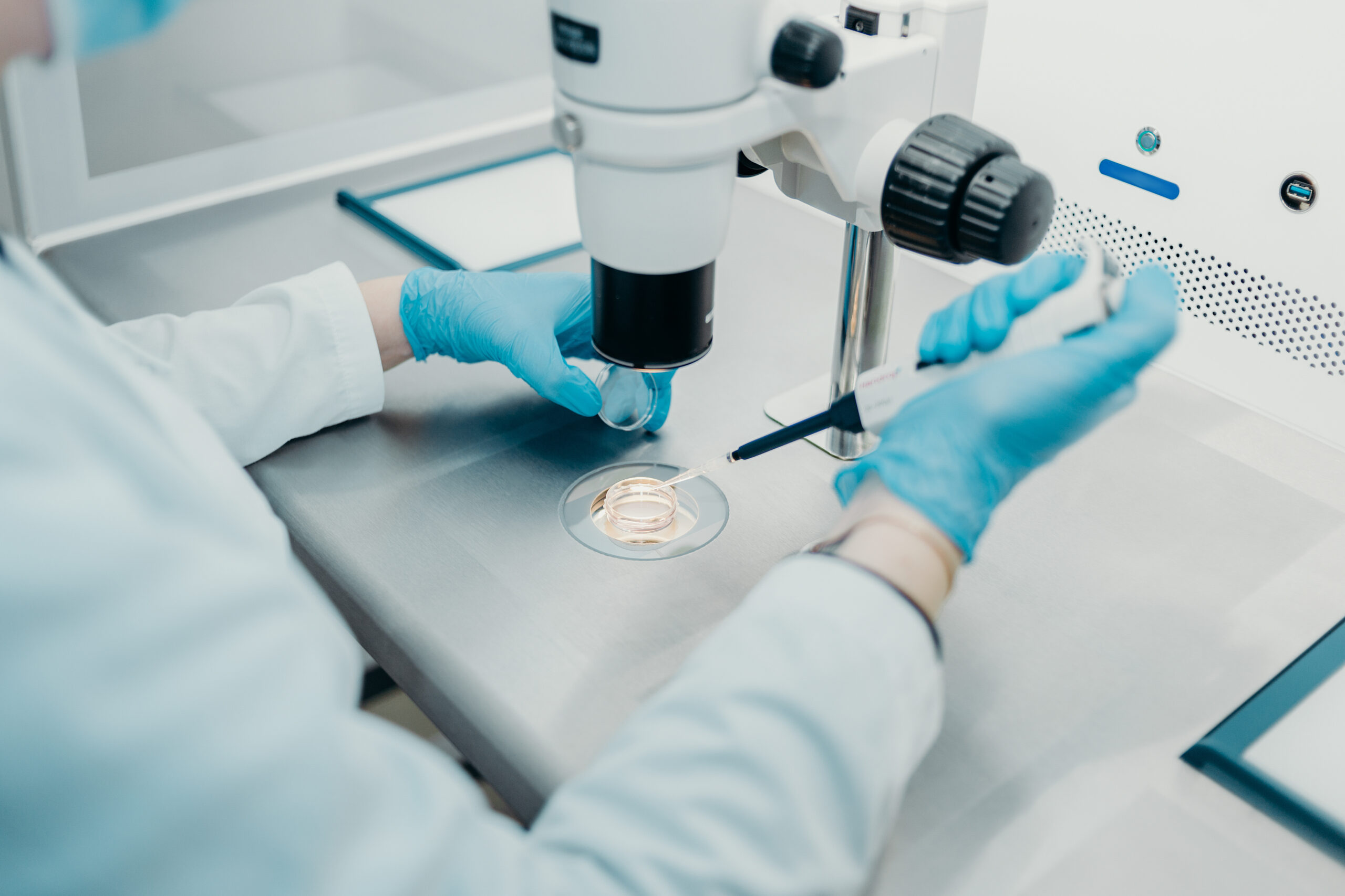 Embryologist working with instruments and utilizing a microscope to perform assisted hatching | Arizona Reproductive Medicine Specialists