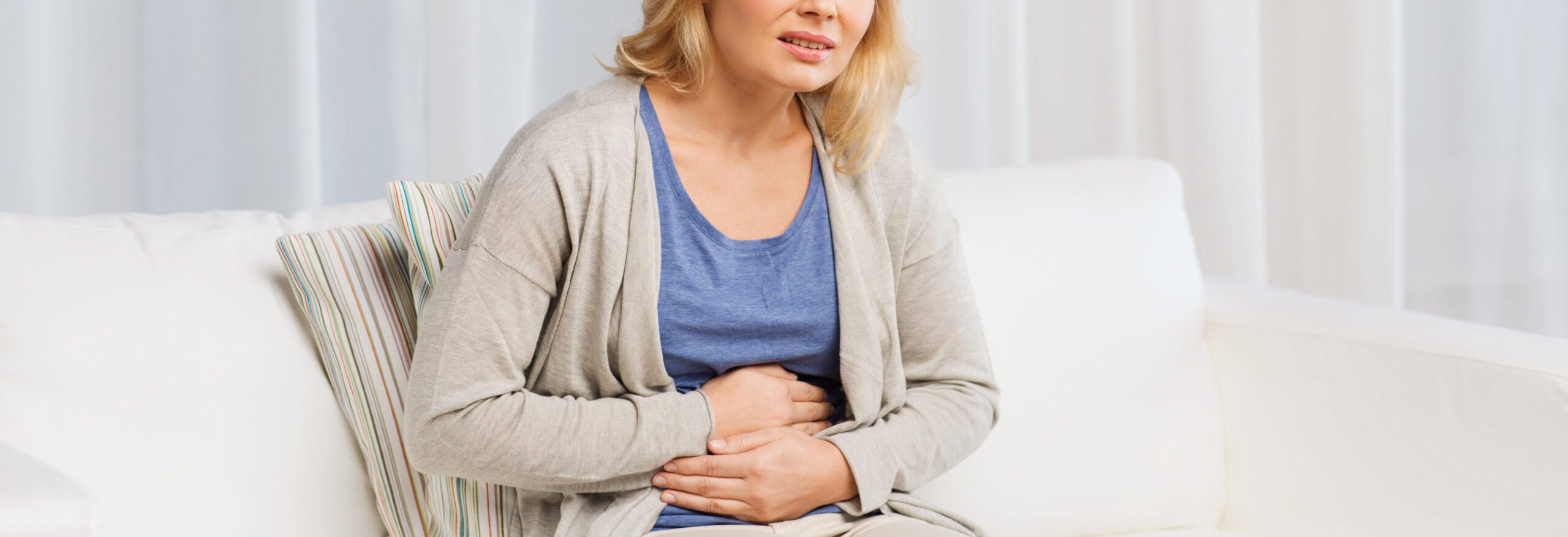 Unhappy woman suffering from stomach ache at home due to pelvic inflammatory disease | Arizona Reproductive Medicine Specialists