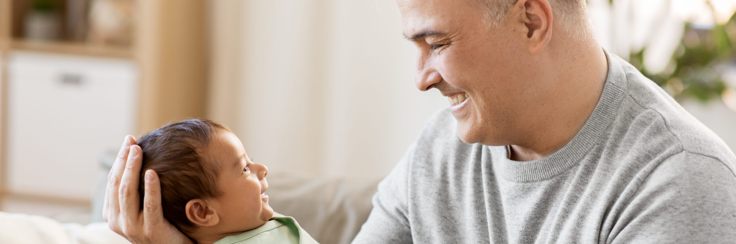 Happy father age with baby boy at home thinking about male infertility age | Arizona Reproductive Medicine Specialists