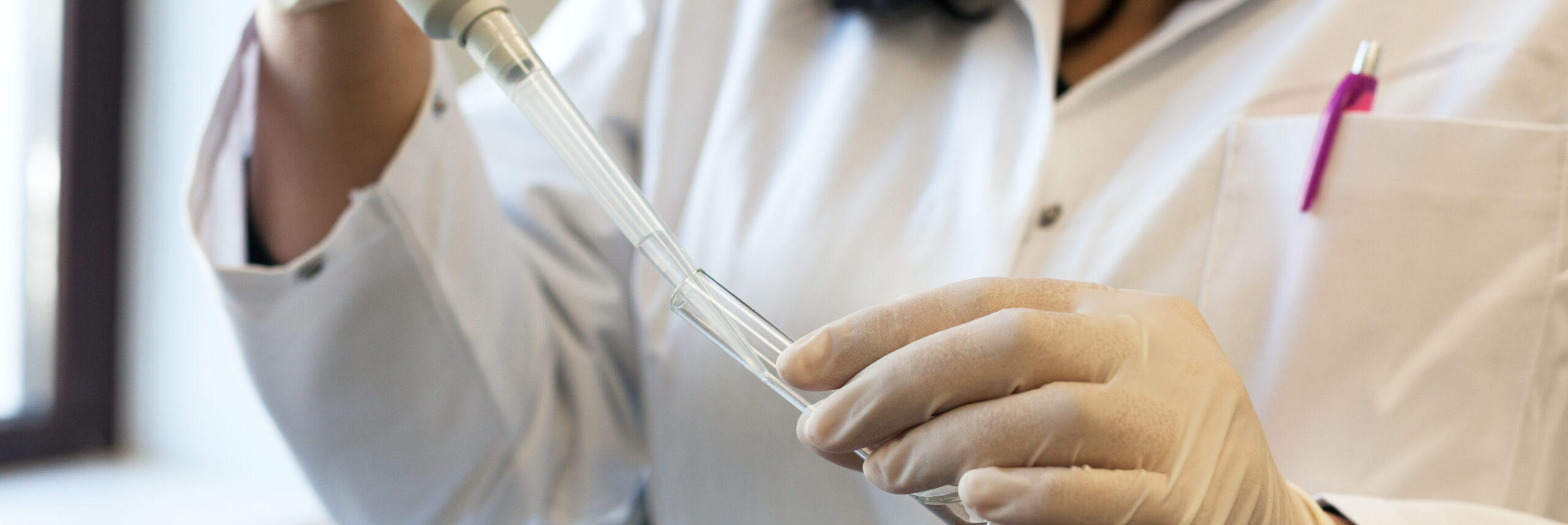 Closeup of a female scientist filling test tube to test chromosome problems | Arizona Reproductive Medicine Specialists
