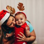 Mom in Santa hat with baby wearing antlers | Arizona Reproductive Medical Specialists
