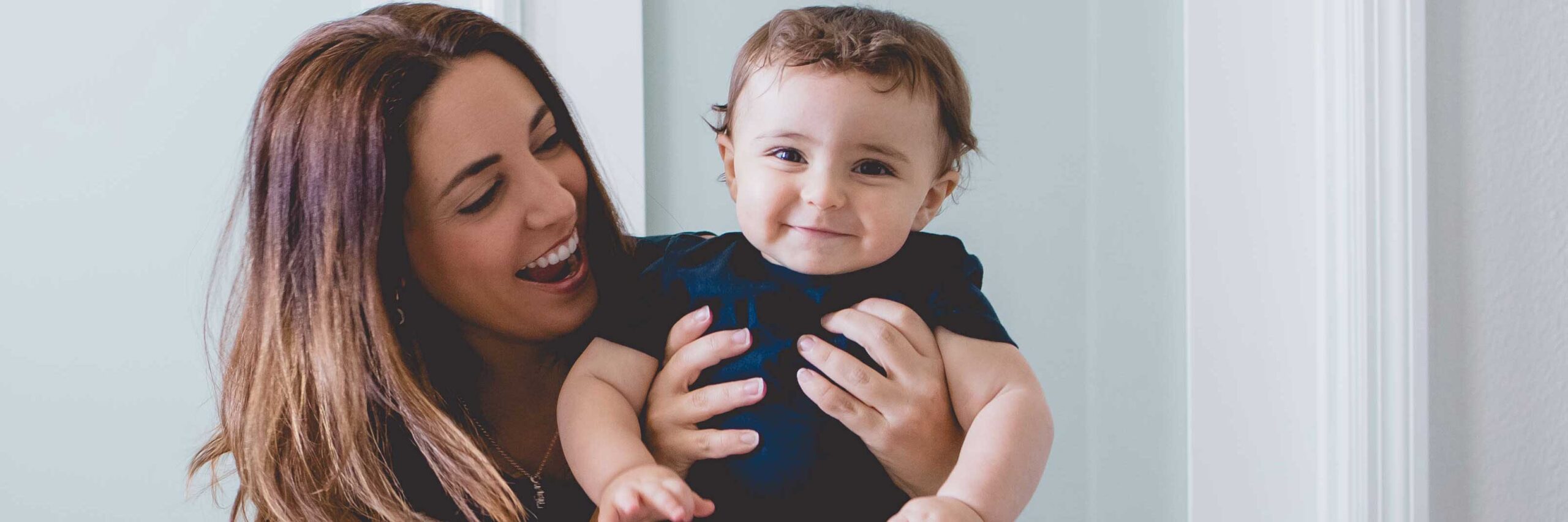 Woman holds baby wearing blue | Diminished Ovarian Reserve | Arizona Reproductive Medicine Specialists